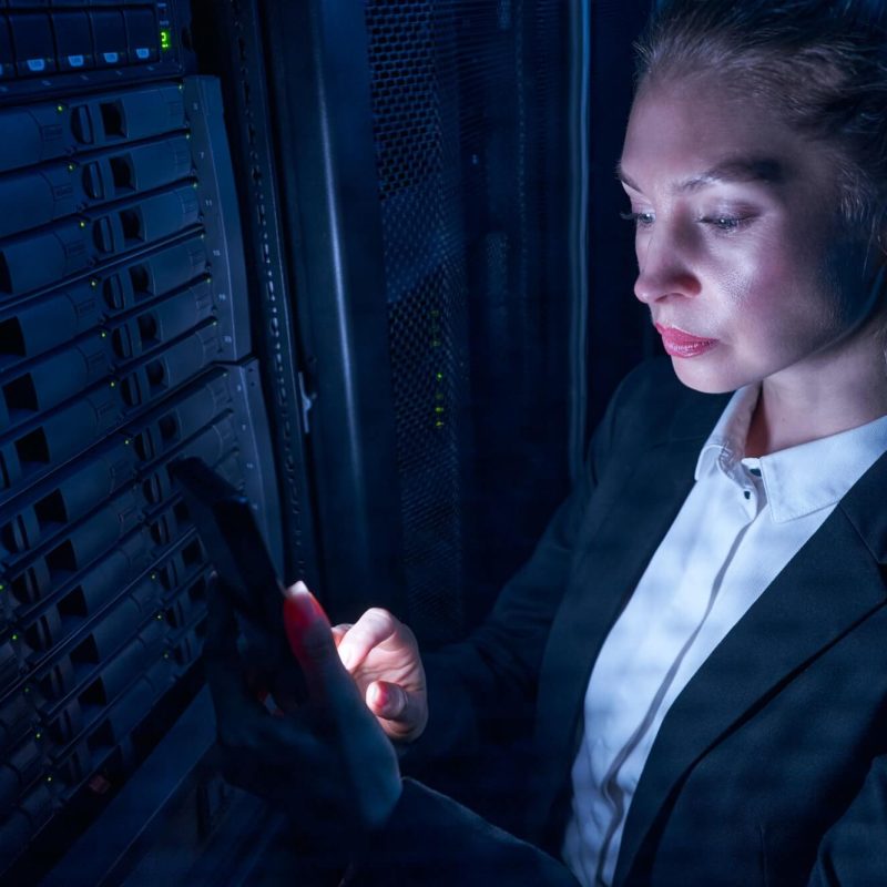 woman-engineer-working-in-datacenter-by-server-storage-racks-1.jpg
